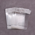 Pile de sacs d'emballage bijoux transparents adhésifs avec cartes de suspension blanches - Sacs OPP Épaissis 7*14cm (100 Pcs)