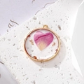 Macro detail of a round golden resin pendant with pink heart petal and gold foil flakes - Gold Foil Heart Petal