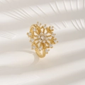 Eleganter goldener Schneeflockenring mit funkelnden Kristallen auf weißem Grund - Schneeflocke Verstellbar Offen / Gold