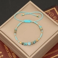 Detailed shot of handmade bohemian turquoise beaded bracelet with blue woven cord - Lake Blue