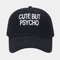 Detail of embroidered 'CUTE BUT PSYCHO' text on black cotton baseball cap with neat stitching - Black