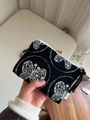 Close-up of black canvas coin purse featuring white butterfly embroidery and a zip closure - Butterfly Embroidery