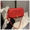 Detail of red leather shoulder bag with gold C-shaped clasp and knotted strap design - Red