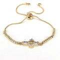 Dettaglio del bracciale a croce d'oro con zirconi chiari e chiusura a scorrimento - Bianco