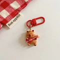 Détail d'un joli porte-clés ours brun avec mini guitare et mousqueton rouge en métal - Capybara - Jouer de la guitare