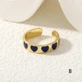 Macro shot of adjustable gold ring with blue enamel hearts on minimalist white surface - Dark Blue Hearts (RG0446-B)