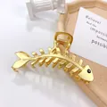 Elegant gold fishbone hair claw clip with black gem eye detail, length 10cm - Fishbone Medium