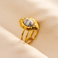 Detailed macro view of an adjustable gold-plated ring with a white marble stone and lava texture - Gold-White