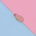 Detailed view of an oval stainless steel pendant tag engraved with S.steel text - Rose Gold