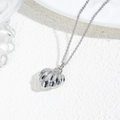 Macro shot of silver-plated hollow pumpkin heart pendant on an O-chain necklace - Pumpkin Shape Pendant Necklace / Silver