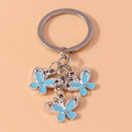 Detail of three blue enamel butterfly charms with rhinestones on a metal keychain - Silver Blue