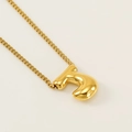 Golden titanium bubble letter J necklace on minimalist beige background chain - Letter J