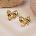 Polished gold bow earrings set against natural stone for a trendy fashion look - Golden Bowtie Style (FYD6151)