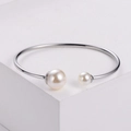 Minimalist silver open bangle featuring asymmetric double pearls on polished steel band - Steel
