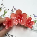 Handheld three-flower acrylic hair claw clip in translucent orange with bead centers - Red