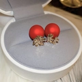 Macro view of festive red bead earrings with golden Chinese character charms in jewelry box - Chinese Character Studs