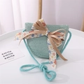 Close-up of mint green straw crossbody bag with floral fabric bow for girls - One Size / Mint Green Bag