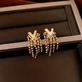 Close-up of golden V-shaped tassel earrings displayed in a dark brown jewelry box - Silver Pin-V Tassel / Gold