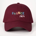 Close-up of a burgundy France 2024 baseball cap featuring colorful striped typography - Burgundy