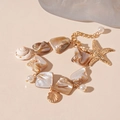 Close-up of golden starfish and seashell charms on a beach style pearl bracelet - Gold Starfish Bracelet