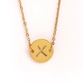 Gros plan d'un collier doré en acier inoxydable avec pendentif pièce ajouré lettre X - Lettre X
