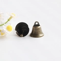 Detailed view of vintage bronze metal bells for DIY crafts with a white floral background - 22mm