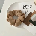 Elegant khaki knit scrunchie with ribbed texture displayed on a white plate - Striped Coffee