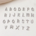 Macro shot of 26 sparkling silver letter pendants with clear cubic zirconia inlays - Letter A / Silver