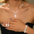 Macro detail of luxury zircon water drop necklace and earrings set on a model - Three-Piece Set / Silver