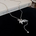 Macro shot of silver hollow horse pendant with tassel on black velvet and book background - Silver Snake Chain Horse Tassel Pendant