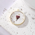Detail of round gold resin pendant featuring purple dried flowers and gold foil flakes - August Pink Rose With Gold Foil