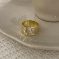 Detail of gold-plated three-layer ring with sparkling zircon inlays on ceramic tray - Gold Zirconia Open Style
