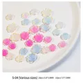 Macro view of aurora camellia nail charms in various sizes and iridescent colors - Camellia Mixed Light Sensitive (S-04)