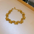 Gros plan détaillé d'un bracelet papillon doré sur un plateau avec son fermoir mousqueton - Bracelet en Acier Titane Papillon Doré