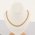Primer plano de collar de eslabones cubanos dorados en un busto de exhibición de joyas - Pulsera 20CM / Dorado