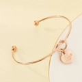 Detalle macro de brazalete abierto bañado en oro de 18K con colgante de corazón Love - Oro rosa