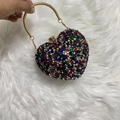 Macro detail of heart-shaped evening bag with multicolor rhinestones and gold handle - Colorful