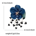 Blaue Stoffblumen-Brosche mit grünen Blättern und schwarzen Perlenquasten auf Weiß - Blau