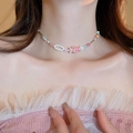 Gros plan d'un ras-de-cou en perles colorées avec pendentif fraise sur le cou du mannequin - Pendentif fraise en perles multicolores (120# Collier)
