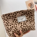Brown leopard print corduroy makeup bag with 'Time to Party' label held by hand - Leopard Smile Coffee