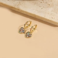 Macro shot of gold hoop earrings with heart charms and colorful inlaid zircons - Heart (ES2590)