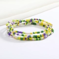 Close-up of colorful beaded body chains in green, yellow, purple, and white glass beads - Green Yellow Purple White