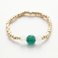 Detail of handmade beaded ring with gold beads and a central green gemstone accent - Gold & Green White