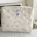 Detailed macro of floral quilted fabric pouch with embroidered elephant patch and pink bow - Nali Elephant Handbag