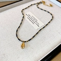 Bohemian zwarte kralenketting met een gouden schelphanger en handige karabijnsluiting - Ketting-Zwart-Schelp
