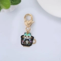 Detail view of teal cat enamel pendant inside a floral teacup with gold heart clasp - Black Flower Cup Cat