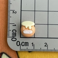 Detailed macro view of a 1cm mini bee honey jar resin charm on a grid ruler mat - Honey Jar
