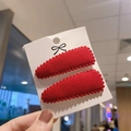 Close-up of two red cashmere-textured teardrop hair clips with beaded edges on a card - Red