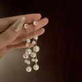 Détail de longues boucles d'oreilles à pompon doré avec perles blanches et strass brillants - Gland en Perle et Strass Doré (025)