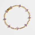 Detalle de la pulsera de flor dorada con circonitas púrpuras y motivos de trébol - Flor Púrpura - Color Dorado